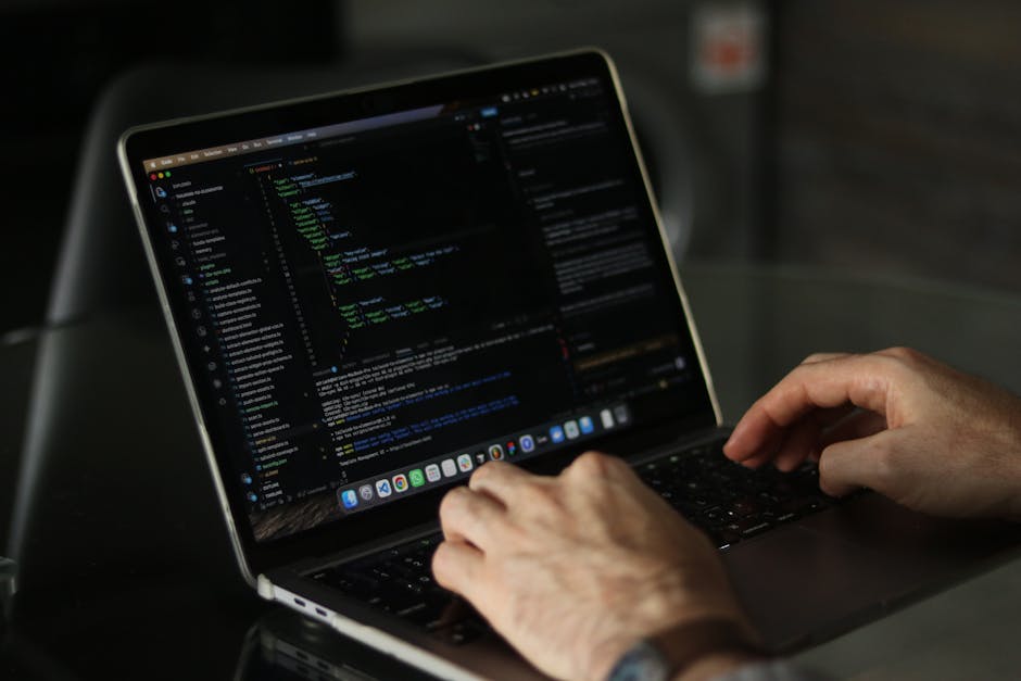 A close-up shot of a computer screen filled with lines of colorful programming code, including syntax highlighting with keywords and symbols in shades of red, green, blue, yellow, and white. The text 